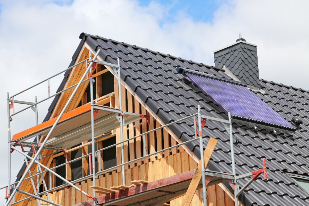 Dach eines Neubaus mit Gerüst und Solarthermieanlage